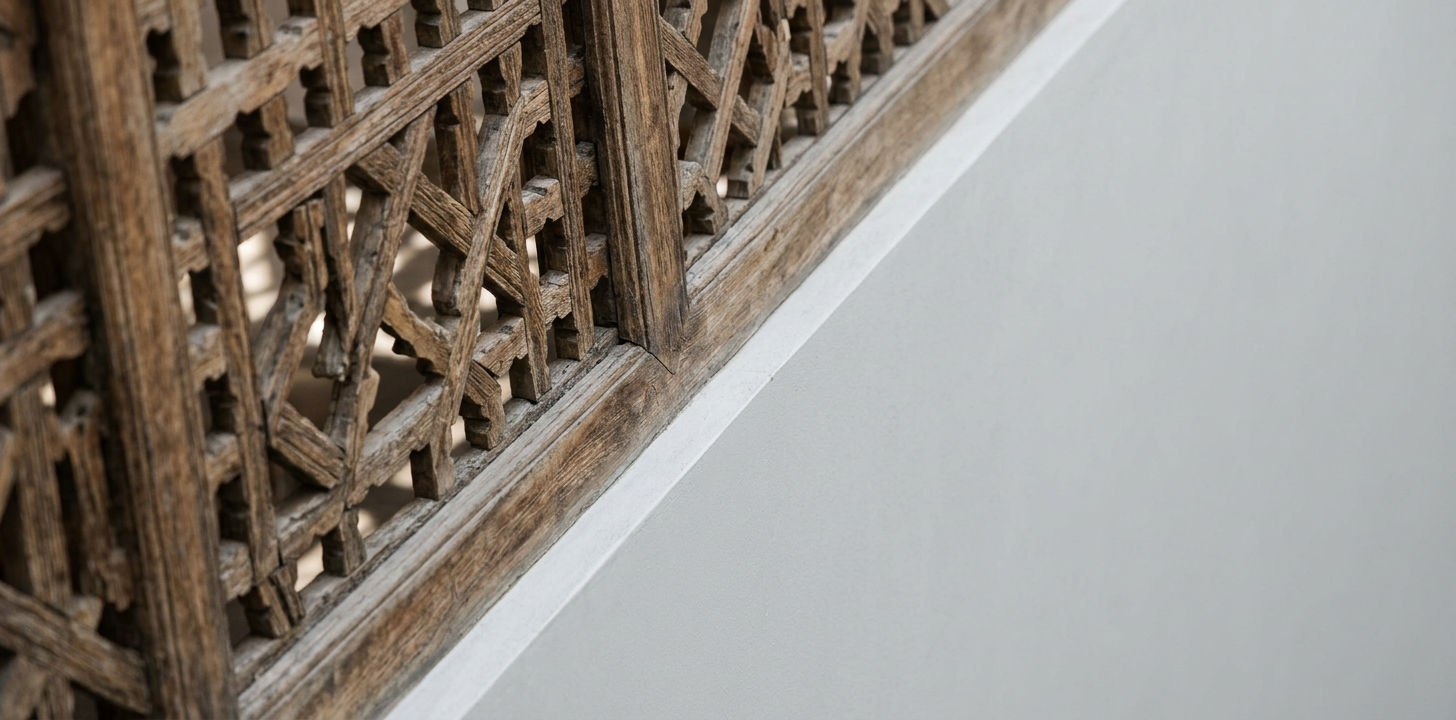 Architectural detail contrasting weathered traditional wooden mashrabiya work with modern minimalist render   